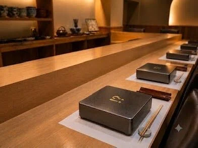 木のカウンターに銀色の重箱を並べた店内イメージ(仮)